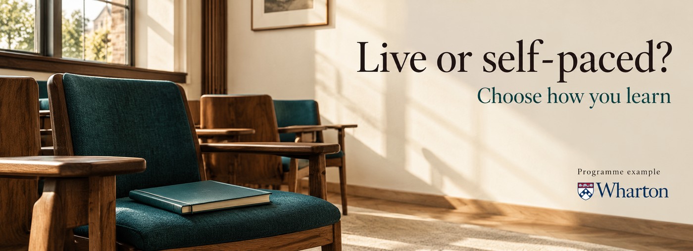 Live or self-paced: an empty lecture room with a workbook on a teal chair.